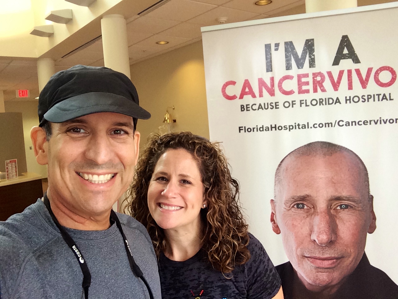 Jason Mendelsohn and wife selfie in front of 'I'm a Cancervivor" banner